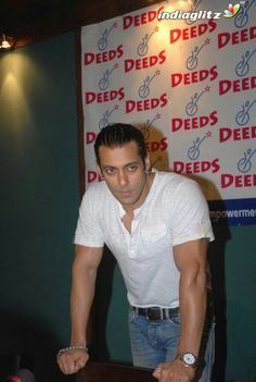 a man standing next to a table in front of a sign