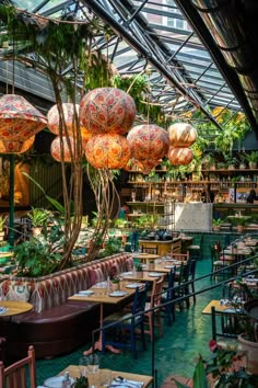 the inside of a restaurant with tables, chairs and umbrellas hanging from the ceiling