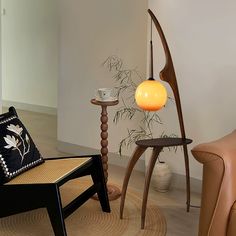 two chairs and a table in a room with wood flooring, one chair has an orange light on it