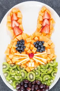 an image of a plate with fruits and vegetables in the shape of a cat's face