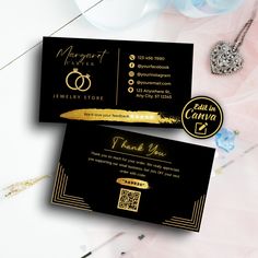 two black and gold business cards sitting next to each other on top of a table