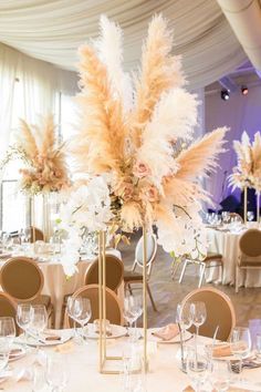 the tables are set with white linens and tall centerpieces