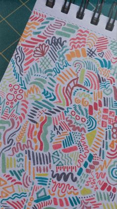 a spiral notebook with colorful doodles on it