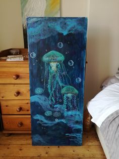 a painting of jellyfish in the ocean on a canvas next to a night stand