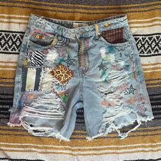 a pair of destroyed shorts with patches on them