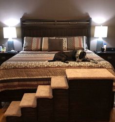 a dog laying on top of a bed in a bedroom next to two nightstands