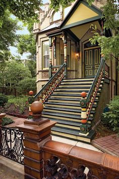 an old house with stairs leading up to the front door