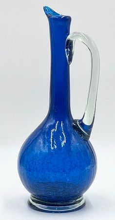 a blue glass pitcher sitting on top of a table