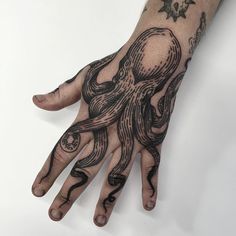 a hand with an octopus tattoo on it