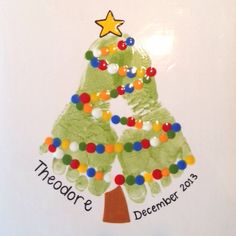 a handprinted christmas tree on a white plate with colorful beads and a star