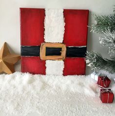 a santa clause painted on the side of a wall next to a christmas tree and presents