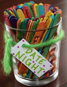 a glass filled with lots of colorful magnets and a sign that says date night