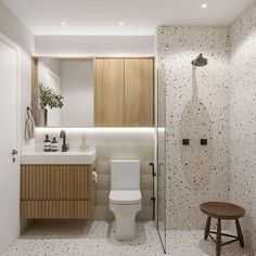 a white toilet sitting next to a walk in shower under a bathroom mirror above a sink