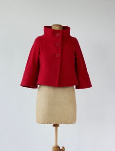 Vintage 1980s - 1990s red cropped wool jacket with wide color and 3/4 sleeves. Closure: 3 large red buttons in front. Label: La Scene Privee, Made in Japan Fabric: Wool   Fully lined Estimated Size S - please check measurements. The measures have been taken with the item flattened out - double bust. Shoulders: 37,5 cm - 14 inches Arm pit to arm pit: 45,5 cm - 18 inches Waist - free Length: 48 cm - 19 inches Sleeves: 44,5 cm - 17,5 inches Very good to Excellent vintage condition Follow us on Inst Winter Cropped Outerwear With Button Cuffs, Winter Cropped Blazer With Buttons, Retro Cropped Outerwear For Fall, Vintage Cropped Outerwear For Winter, Winter Wool Cropped Jacket With Buttons, Vintage Cropped Winter Outerwear, Red Fitted Cropped Outerwear, Fitted Vintage Red Outerwear, Vintage Red Outerwear With Buttons