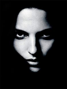 a black and white photo of a woman's face with her eyes wide open