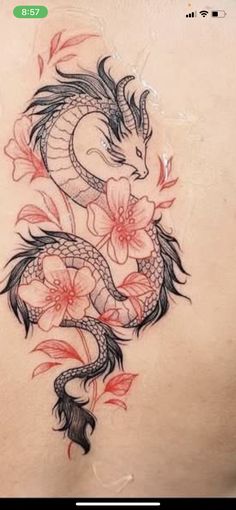 a woman's back with a dragon and flowers tattoo design on her side ribcage