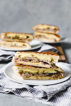 a sandwich cut in half sitting on top of a white plate