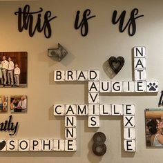 a cross made out of scrabble tiles with family pictures on the wall