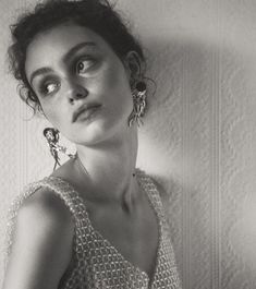 a black and white photo of a woman wearing earrings