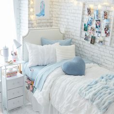 a bedroom with white brick walls and light blue comforter on the bed, along with pictures hanging on the wall