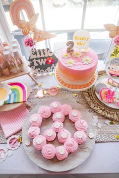 a table topped with lots of cakes and cupcakes