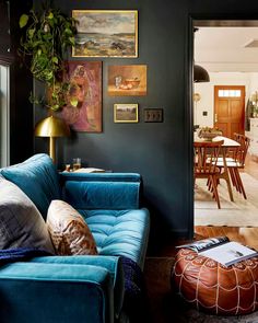 a living room with blue couches and pictures on the wall above it's door