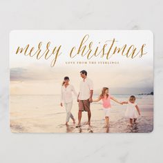 a merry christmas card with an image of three people holding hands and walking in the water