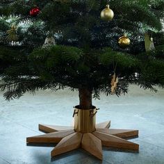 a small christmas tree in a wooden stand