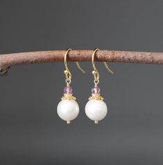 "Lustrous and opalescent white Akoya pearls are wire wrapped with balled gold pins and topped with gold caps and faceted Pink Quartz stones. These dangle from gold balled earwires. These classic pearl earrings are a wonderful addition to any jewelry wardrobe and are perfect to give as bridal gifts.  Multiple pairs can be ordered. A matching pendant is also available.  Want these in a different color?  Please send a message! Pink Quartz stones: 3mm Akoya pearls: 9mm Total length of earrings: 1 1/ White Pearl Crystal Earrings For Pierced Ears, White Pearl Crystal Earrings, White Crystal Pearl Drop Earrings As Gift, White Wire Wrapped Round Pearl Earrings, White Pearl Earrings With Ear Wire, Elegant White Crystal Earrings With Ear Wire, Elegant Wire Wrapped Crystal Earrings, Delicate White Wire Wrapped Pearl Earrings, Elegant Wire Wrapped White Crystal Earrings