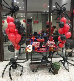 some balloons and spider man decorations on a table