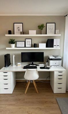 a white desk topped with a computer monitor next to a printer and other office supplies