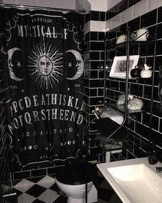 a black and white bathroom with a shower curtain that has the moon and stars on it