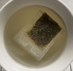 a tea bag in a white bowl filled with water