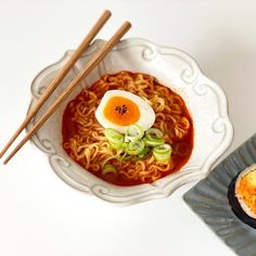 an egg and ramen dish with chopsticks on the side