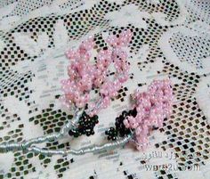 two pink flowers sitting on top of a lace covered table cloth next to each other