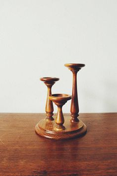 two wooden candlesticks sitting on top of a wooden table