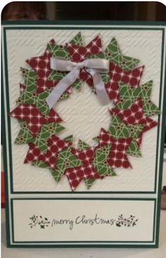 a christmas card with a green and red wreath