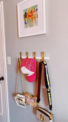 the purses are hanging on the hooks in the wall next to the hat rack