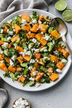 a white plate topped with cucumber, feta cheese and broccoli