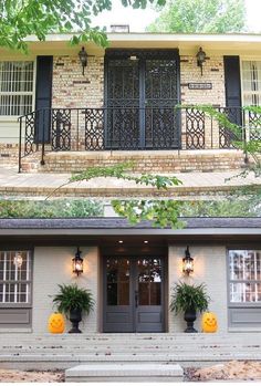 the front and side of a house decorated for halloween with pumpkins on each door