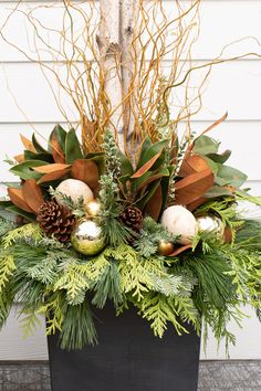 a planter filled with greenery and christmas decorations