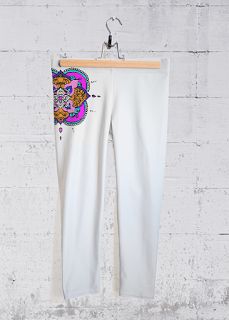 the white pants are hanging up against a brick wall with a colorful paisley design on it