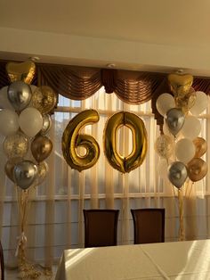 balloons and streamers are set up in front of a window with the number 60 on it