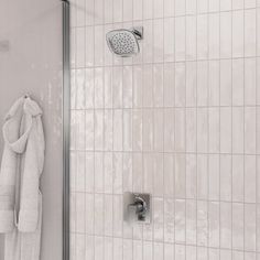 a white towel hanging on the side of a shower