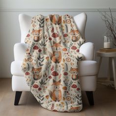 a chair with a blanket on top of it next to a white chair and table