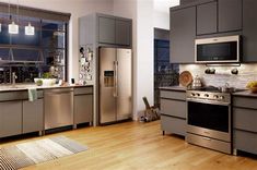 a modern kitchen with stainless steel appliances and wood floors