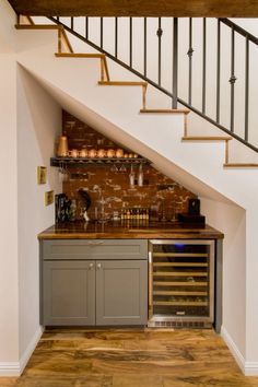 a wine rack under the stairs in a home bar with built - in wine bottles