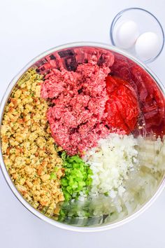 the ingredients for this meatloaf are in a bowl with an egg on the side