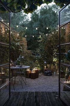 an outdoor dining area is lit up with string lights