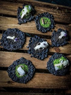 four small black and white plates with food in them on top of a wooden table